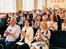 Глядачі в залі, серед них — випускники, батьки та освітяни, аплодують під час урочистого заходу Бахмутської громади.