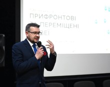 Спікер виступає на подіумі дискусії з мікрофоном