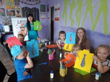 Діти за столом показують виготовлені ними поробки