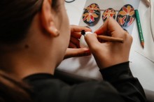 Учасниця майстер класу розписує писанку.