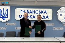 Керівники громад тиснуть руки та тримають підписаний меморандум