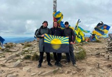 Троє чловіків тримають прапор Донеччини на Говерлі