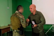 Вадим Філашкін нагороджує бійця нагрудним знаком