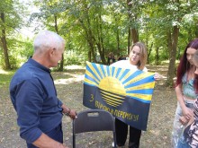 Дівчина тримає прапор Донецької області з написом "З вірою в Перемогу"