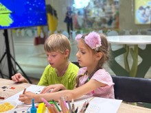 Хлопчик та дівчинка малюють на майстер-класі