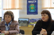 Учасники зустрічі сидять за столом.