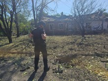 Правоохоронець стоїть поруч із зруйнованим одноповерховим будинком