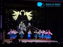 У Народному домі міста Шептицького творчий захід «Розколяда», актори на сцені тримають стрічки та ходять по кругу.