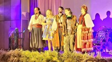 П’ятеро акторів у яскравому сценічному вбранні співають на сцені