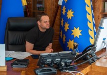 Олексій Кулеба сидить за столом та дивиться в монітор