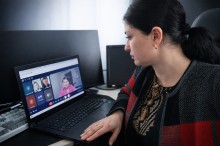 Представник військової адміністрації сидить за столом та слухає доповідача на семінарі