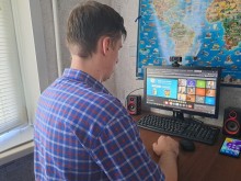 Молодий чоловік біля ноутбука. На онлайн зустрічі, де учасники діляться досвідом молодіжної діяльності в умовах повномасштабного вторгнення.