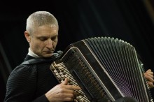 Виконавець грає на баяні.