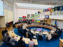 Загальний план круглого столу, на задньому фоні видно прапори бойових підрозділів