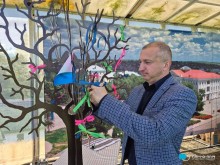 Заступник Бахмутського міського голови Сергій Родін прикрашає символічне дерево