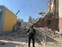 Правоохоронець стоїть біля зруйнованої будівлі