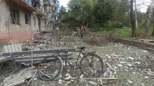 Велосипед стоїть у дворі зруйнованої окупантами багатоповерхівки