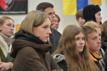 Глядачі уважно дивляться картини, представлені на виставці