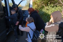 Родина з дітьми сідає до евакомобіля