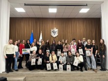 Спільне фото.
Хлопці та дівчата тримають у руках паперові пакети та посміхаються