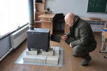 Вадим Філашкін оглядає пічку буржуйку, яка призначена для опалення пункту незламності