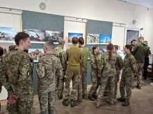 Військовослужбовці переглядають представлені на виставці картини