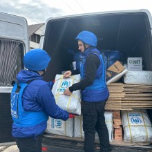 Волонтери вигружвють з автомобіля гуманітарну допомогу.