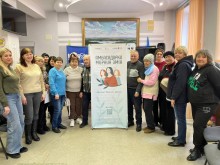 Спільне фото учасників діалогової зустрічі, посередині борд організаторів.