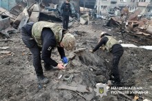Поліцейські збирають уламки снарядів після обстрілу.