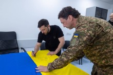 Президент України підписує прапор для медиків.