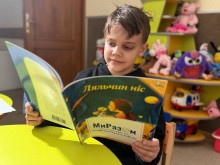 Дитина посміхаэться, тримаючи новеньку книжку