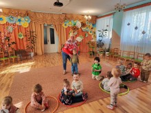 Практика студентки педколеджу: заняття з фізкультури з дошкільнятами в затишній, барвистій груповій кімнаті дитсадка.