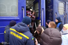 Волонтери та рятувальники допомагають людям вийти з евакуаційного потяга
