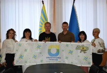 Представники громад тримають прапор Очеретинської громади.