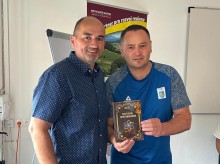 Представники делегації тримають книжку та посміхаються.