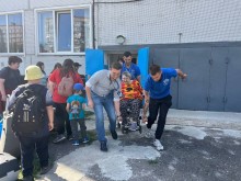 Благодійники та працівник транзитного хабу, допомагають маломобільній людині у кріслі колісному