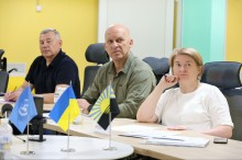 Сергій Боєвський, Вадим Філашкін та Оксана Головко слухають доповідь представників УКГС ООН