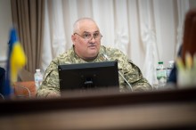 Амбасадор безбар’єрності Юрій Іваськевич у військовій формі та окулярах виступає за столом з мікрофоном