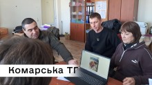 Спеціалісти Комарської громади за столом опрацьовують ескіз майбутньої вишиванки