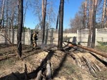 Рятувальник гасить вогонь біля дерев після удару КАБом по Святогірську