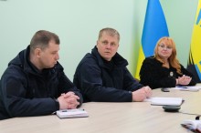 Учасники наради сидять за столом.