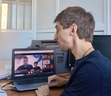 Представник військової адміністрації сидить за столом та слухає доповідача на семінарі