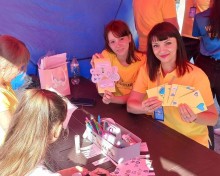 Студентки коледжу з дітьми створюють листівки для військових у межах патріотичної ініціативи під час літніх канікул.