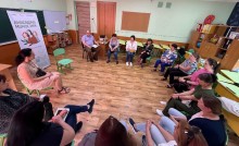 Учасники проєкту «Амбасадорки мирних змін» сидять у колі під час обговорення в класній кімнаті