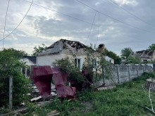 Будинок у приватному секторі з пошкодженою покрівлею та парканом через ворожі обстріли.