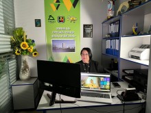 Представник військової адміністрації сидить за столом та слухає доповідача на семінарі