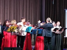 Оркестр грає на сцені, солістки співають