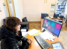 Представник військової адміністрації сидить за столом та слухає доповідача на семінарі