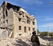 Правоохоронець дивиться на зруйновану багатоповерхівку
