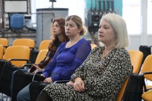 Учасники зустрічі. Жінки сидять на помаранчевих кріслах.